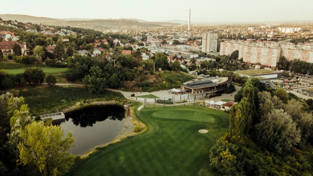 A golfpálya madártávlatból, háttérben Budapest